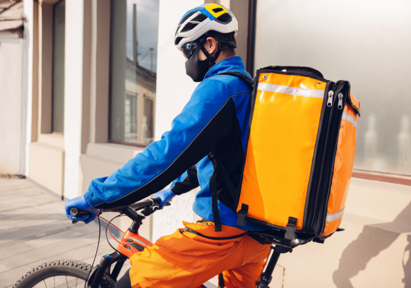 An image of a man riding an E-Bike, and carrying a large backpack