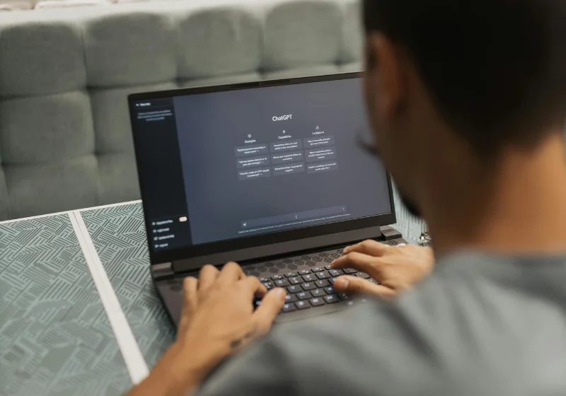 An image of a man using ChatGPT on his laptop